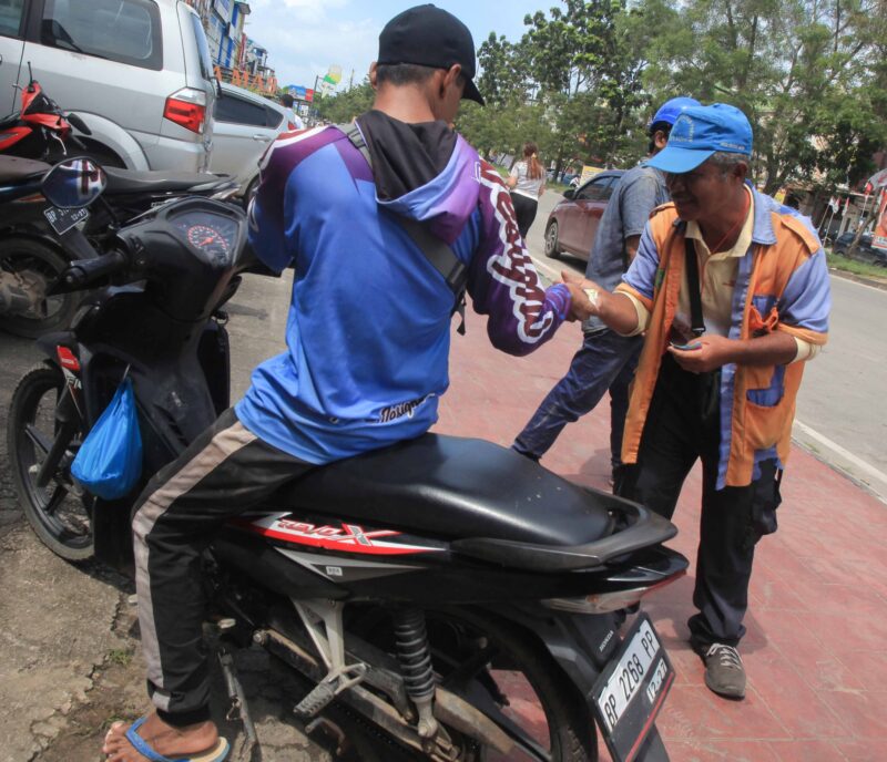 Juru parkir (jukir) menarik retribusi parkir kepada pengendara di Batam, Senin (15/1/2024) Matapedia6.com/ luci