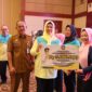 Ketua TP-PKK Provinsi Kepulauan Riau Dewi Kumalasari Ansar, menyerahkan bantuan dana kepada kader posyandu di sela Kegiatan Workshop Peningkatan Kompetensi Kader Posyandu bertempat di Aula Wan Sri Beni, Dompak Tanjungpinang, Senin (29/7/2024). Matapedia6.com/Diskominfo