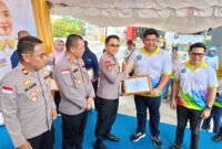 Bupati Bintan Roby Kurniawan memberikan piagam penghargaan kepada Kapolres Bintan AKBP Riky Iswoyo, bersamaan peringatan hari anak nasional di Bintan. Matapedia6.com, Dok Polres