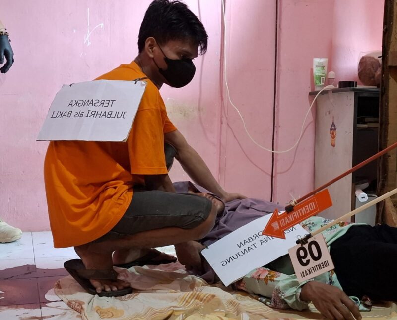 Pelaku saat hendak menarik jenazah korban memindahkan ke kamar tempat pelaku tidur, setelah korban sudah tidak bernyawa. Rekonstruksi kasus pembunuhan di Sagulung, Jumat (2/8/2024).Matapedia6.com/ Luci