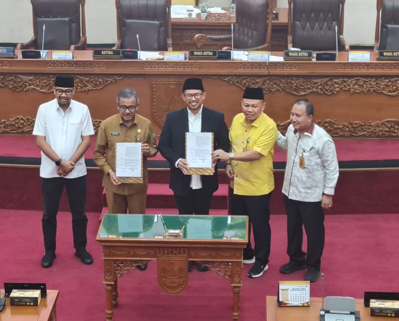 Ketua DPRD Kota Batam Nuryanto dan Sekda Batam Jefridin menunjukkan draf Rancangan Peraturan Daerah (Ranperda) tentang Rencana Pembangunan Jangka Panjang Daerah (RPJPD) Kota Batam tahun 2025-2045 usai dilakukan penanda tanganan, Senin (5/8/2024).Matapedia6.com/Luci