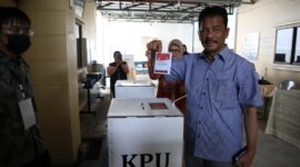 Rudi hendak masukan surat suara ke kotak, Rabu (27/11). Foto:Istimewa