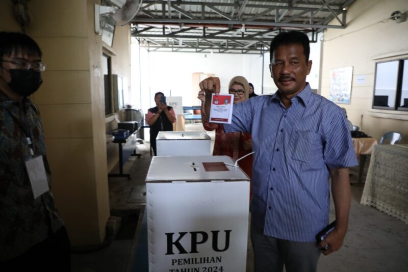 Rudi hendak masukan surat suara ke kotak, Rabu (27/11). Foto:Istimewa