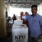 Rudi hendak masukan surat suara ke kotak, Rabu (27/11). Foto:Istimewa