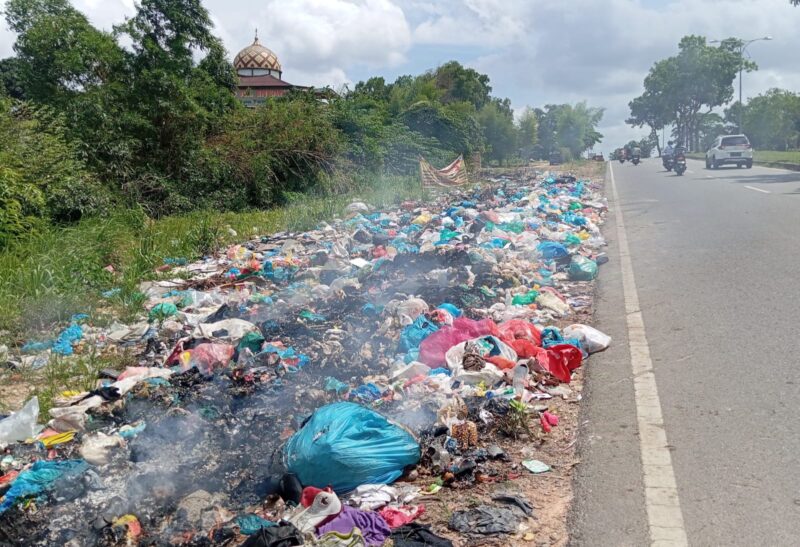 Tumpukan sampah dan asap dari pembakaran sampah ganggu pengendara yang hendak ke Jembatan Barelang, Minggu (5/1/2025). Matapedia6.com/Luci.