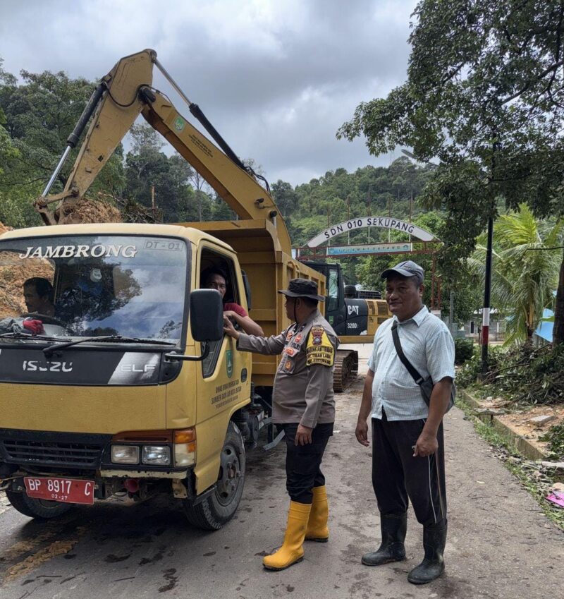 Petugas kepolisian dari Polsek Sekupang dan juga Dinas Bina Marga Kota Batam saat mengangkat material tanah longsor di Tiban Lama, Kecamatan Sekupang, Kamis (16/1/2025). Matapedia6.com/ Dok Polsek