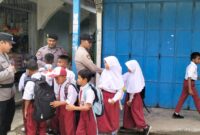 Anggota Polsek Bulang saat membantu anak didik sekolah dasar menyeberang di jalan raya,  Kamis (23/1/2025) Matapedia6.com/ Dok Hendra Citra