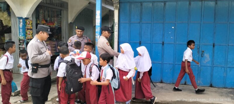 Anggota Polsek Bulang saat membantu anak didik sekolah dasar menyeberang di jalan raya,  Kamis (23/1/2025) Matapedia6.com/ Dok Hendra Citra