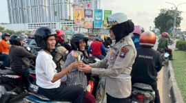 Anggota Ditlantas Polda Kepri saat memberikan bingkisan bunga kepada pengendara yang sudah tertib berlalu lintas di Simpang Frengky Kota Batam, Jumat (14/2/2025). Matapedia6.com/Dok Humas Polda