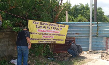 Spanduk penolakan warga yang dipasang di pagar tembok perumahan permata Baloi atas pembukaan akses jalan dari Baloi apartemen lewat komplek permata Baloi, Jumat (18/4/2025) Matapedia6.com/Luci