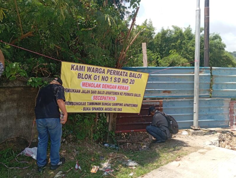 Spanduk penolakan warga yang dipasang di pagar tembok perumahan permata Baloi atas pembukaan akses jalan dari Baloi apartemen lewat komplek permata Baloi, Jumat (18/4/2025) Matapedia6.com/Luci