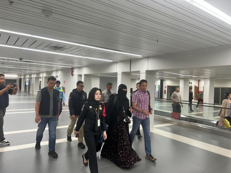 Penyidik Ditreskrimum Polda Kepri saat mnggiring salah satu tersangka yakni DS setelah dipulangkan dari Singapura, Minggu (4/5/2025). Matapedia6.com/Dok Humas Polda