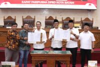 Ketua DPRD Batam Muhammad Kamaluddin bersama pimpinan DPRD Batam dan wali Kota Batam Amsakar Ahmad menunjukkan perda yang sudah disahkan pada rapat paripurna di ruang sidang utama DPRD Batam, Rabu (18/6/2025). Matapedia6.com/Dok DPRD