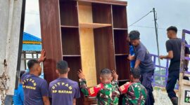 Petugas saat membantu barang warga yang akan pindah ke Tanjung Banon