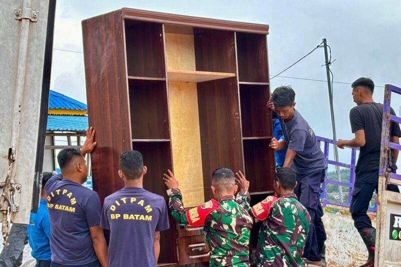 Petugas saat membantu barang warga yang akan pindah ke Tanjung Banon