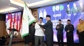 Ketua BWI Batam Buralimar mengibarkan bendera petaka usai dilantik sebagai ketua oleh Wakil Ketua BWI Pusat, Tatang Astarudin di lantai IV Kantor Wali Kota Batam, Rabu (13/8/2025). Matapedia6.com/Diskominfo