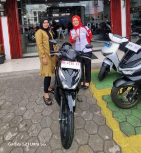 Lia saat berfoto di samping motor yang baru dibelinya secara tunai pakai uang koin hasil tabungan selama dua tahun