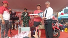 Ketua RW pasar Aviari Abun saat menyerahkan hadiah sepeda motor kepada pemenang undian pesta HUT ke-80 RI di pasar Aviari, Sabtu (30/8/2025). Matapedia6.com/Rega