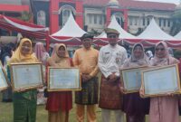 Kepala MIN Tanjungpinang, Suriyati menerima penghargaan Adiwiyata dari Wali Kota Tanjungpinang. Foto:dok/Humas Kemenag