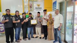 Wakil Ketua II Badan Amil Zakat Nasional (Baznas) Kota Batam, Muhith Marzuqi Sodho (empat dari kanan) menyerahkan piagam penghargaan kepada Ketua PWI Kepri Saibansah Dardani di Kantor Baznas Kota Batam, Senin (8/12/2025) sore. Foto:Istimewa