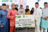 Sekda Batam Firmansyah saat menyerahkan simbolis bantuan Baznas. Foto:Diskominfo