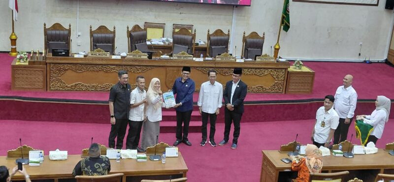 Ketua panitia pembentukan Ranperda LAM menyerahkan dokumen rancangan kepada Wali Kota Batam Amsakar Achmad di ruang sidang Utama DPRD Batam, Rabu (7/1/2025). Matapedia6.com/Luci