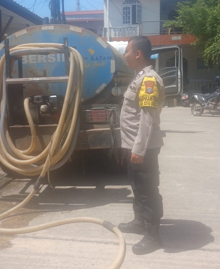 Anggota Polsek Batu Ampar saat mengawal distribusi air bersih di Tanjung Sengkuang pada Sabtu (24/1/2026). Foto:Dok/Polsek