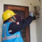 Petugas PLN tengah periksa meteran listrik salah satu rumah. Foto:Dok. PLN