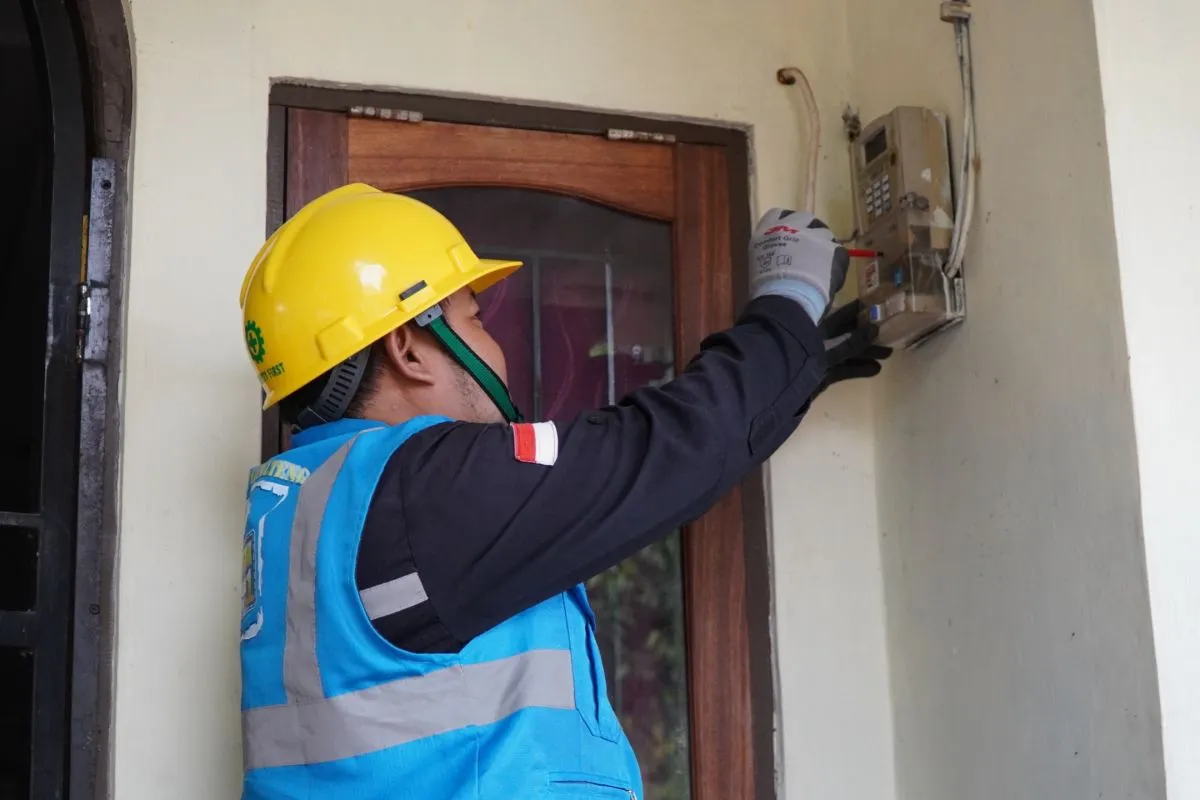 Petugas PLN tengah periksa meteran listrik salah satu rumah. Foto:Dok. PLN