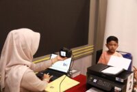 Petugas Imigrasi saat mengambil foto untuk proses pembuatan paspor di waktu hari libur. Foto:Istimewa