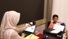 Petugas Imigrasi saat mengambil foto untuk proses pembuatan paspor di waktu hari libur. Foto:Istimewa