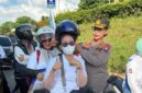  Kabid Humas Kombes Pol Dr Nona Pricillia Ohei memasangkan  helm pada pekerja di acara May Day, Jumat (1/5/2026). Foto: Humas Polda 