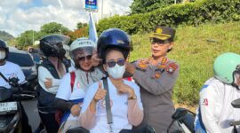  Kabid Humas Kombes Pol Dr Nona Pricillia Ohei memasangkan  helm pada pekerja di acara May Day, Jumat (1/5/2026). Foto: Humas Polda 