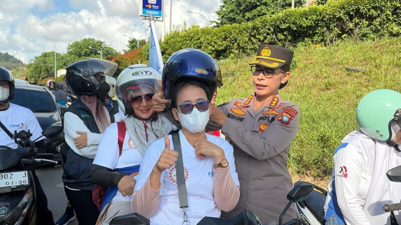  Kabid Humas Kombes Pol Dr Nona Pricillia Ohei memasangkan  helm pada pekerja di acara May Day, Jumat (1/5/2026). Foto: Humas Polda 